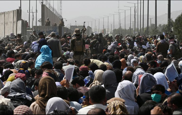 Cientos de afganos esperan en el aeropuerto de Kabul la oportunidad para salir del país. AFP / W. Kohsar
