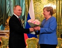Vladimir Putin le entregó un ramo de flores a Angela Merkel en su reunión hoy en el Kremlin, en Moscú. EFE/Sputnik/Kremlin
