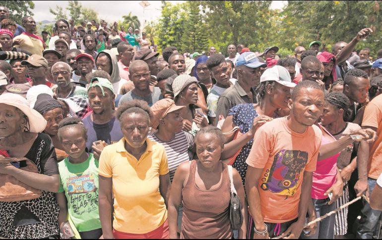 Cientos de haitianos esperan formados por víveres para sus familias. EFE/O. Barría