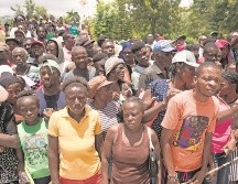 Cientos de haitianos esperan formados por víveres para sus familias. EFE/O. Barría