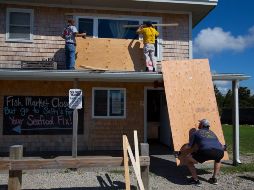 Personas cubren las ventanas como preparación para la llegada del huracán 
