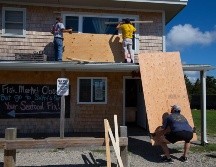 Personas cubren las ventanas como preparación para la llegada del huracán 