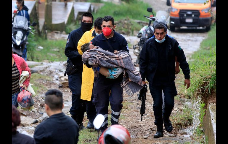 Un menor fue rescatado con vida de la vivienda sepultada en Xalapa. AFP/E. Murillo