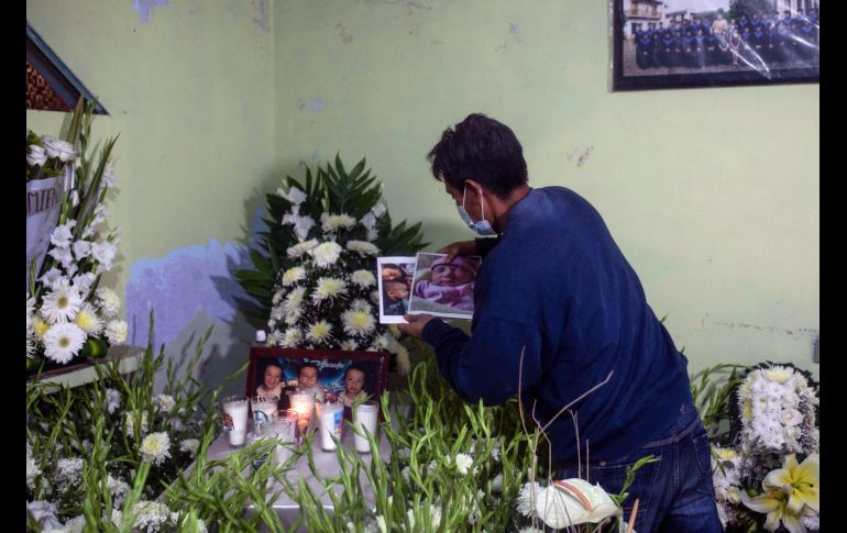 Adán Moreno colocó ayer fotos de su esposa e hijos fallecidos en un altar hechizo en Xalapa, Veracruz. AP/F. Marquez