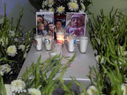 Adán Moreno colocó ayer fotos de su esposa e hijos fallecidos en un altar hechizo en Xalapa, Veracruz. AP/F. Marquez