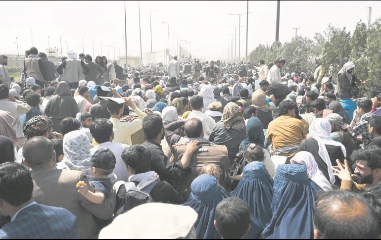 Miles de personas esperan la oportunidad de abordar un avión para salir de Afganistán, tras la llegada del régimen Talibán. AFP/W. Kohsar