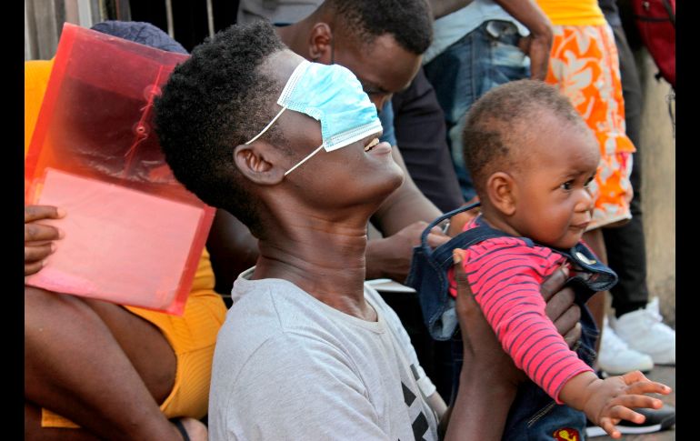 Un migrante con un niño en brazos se une a la manifestación. EFE/J. Blanco