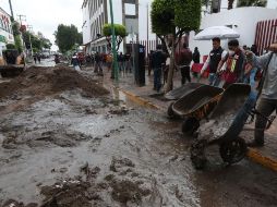 Habitantes de los barrios afectados por una intensa lluvia remueven barro de las calles en el municipio de Ecatepec. EFE/M. Guzmán
