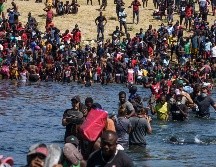 Migrantes haitianos que se alojan en un campamento en Texas cruzan hoy el río Bravo cerca de Del Río hacia Ciudad Acuña, con el fin de obtener alimentos del lado mexicano. AFP/P. Ratje