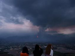 Unas niñas buscan con prismáticos su vivienda en el barrio de El Paraíso, una de las zonas más afectadas por la erupción que tiene lugar en la isla de La Palma. EFE/R. de la Rocha