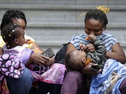 Mujeres haitianas cargan a sus niños en espera de respuesta a sus solicitudes de asilo. XINHUA/F. Cañedo