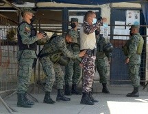 Soldados catean hoy a un policía en el ingreso a la cárcel de Guayaquil, donde ayer se registró la disputa entre reos. AFP/F. Méndez