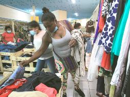 Migrantes varados en Ciudad Juárez, en espera de que Estados Unidos defina sus solicitudes de asilo, escogen ropa usada que fue donada por activistas. EFE/L. Torres