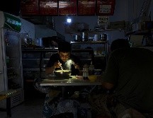 Muchos se han visto forzados a depender de generadores para sus hogares y comer a la luz de sus celulares. AP/O. Zhang