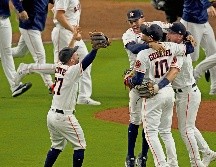 José Altuve corre a abrazar a sus compañeros al caer el último out con el que ganaron el sexto juego a Boston. AP/S. Ogrocki