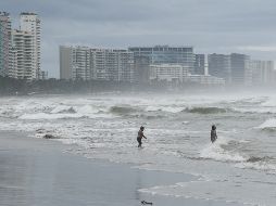 Personas se bañan en una playa mientras el huracán 