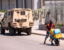 Un hombre carga con bidones en busa de gasolina. La carestía de los combustibles ha provocado jornadas de protestas. EFE/O. Barría