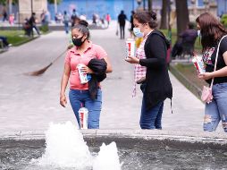 Personas con cubrebocas caminan por un parque del Centro Histórico de la Ciudad de México. EFE/C. Ramírez