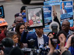 El nuevo alcalde de Nueva York, Eric Adams (C), sostiene un retrato de su difunta madre Dorothy Mae Adams mientras habla con medios de comunicación. AFP/E. Jones