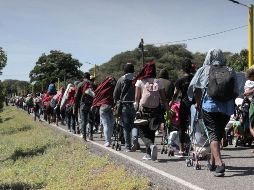 La madrugada este lunes, los migrantes reanudaron su camino hacia Chahuites caminando sobre la carretera Panamericana para evitar que el cansancio y el calor del asfalto, se sumen a la fatiga que llevan a cuestas. EFE / J. Blanco