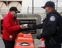Un agente estadounidense de Protección Fronteriza y Aduanas solicita el certificado de vacunación anti COVID-19 a un hombre que quieren cruzar de Ciudad Juárez a El Paso. AFP/H. Martínez