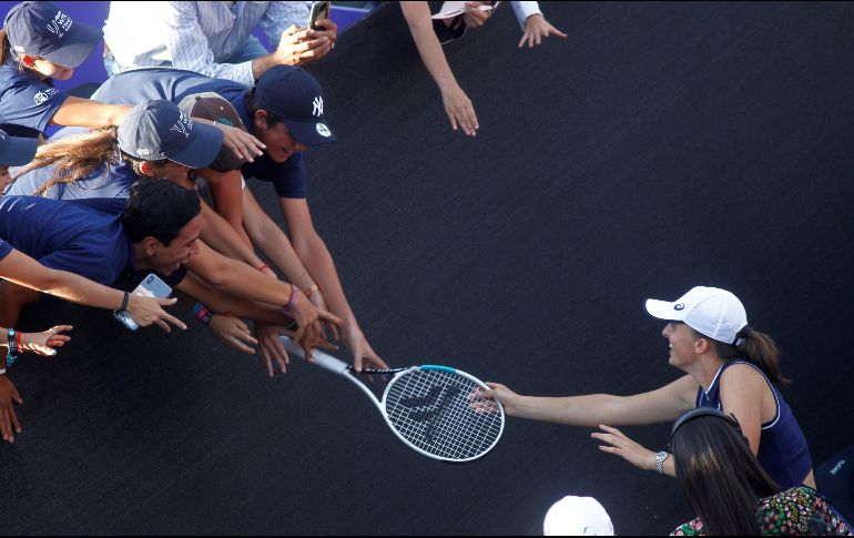 La polaca Iga Swiatek regala su raqueta a unos fans tras  ganar el juego ante la española Paula Badosa, en el torneo AKRON WTA Finals. EFE/ F. Guasco