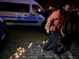 Activista por los migrantes deja veladoras en el puerto de Calais. La de ayer es la mayor tragedia en le canal de la Mancha. AP/M. Spingler