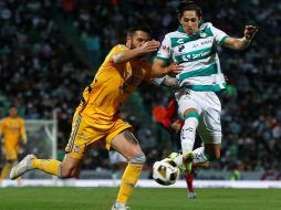 André-pierre Gignac disputa el balón con Alan Cervantes, durante la ida de los cuartos de final del Torneo Apertura 2021. EFE / A. Herrera