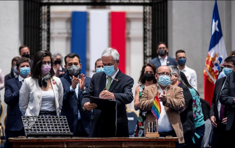 El presidente Sebastián Piñera promulga la ley que permite el matrimonio igualitario durante una ceremonia en el Palacio de Moneda, en Santiago. EFE/Presidencia de Chile