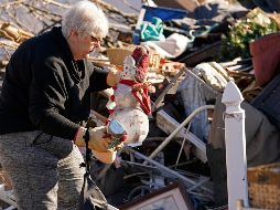 Una mujer rescata un adorno navideño de entre los escombros de su vivienda destrozada, en Mayfield. AP/G. Herbert