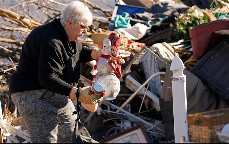 Una mujer rescata un adorno navideño de entre los escombros de su vivienda destrozada, en Mayfield. AP/G. Herbert
