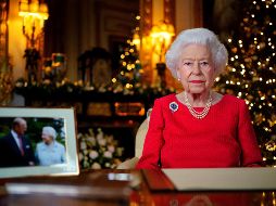 La reina Isabel II apareció con un vestido rojo, sentada junto a una fotografía de 2007 en la que ella y su marido se miran y se sonríen, tomada durante sus bodas de diamante (60 años de matrimonio). AFP