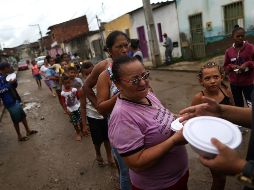Autoridades y voluntarios distribuyen artículos de primera necesidad. AP/R. Muller
