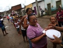 Autoridades y voluntarios distribuyen artículos de primera necesidad. AP/R. Muller