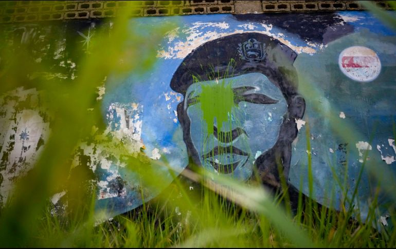 La hierba crece alrededor de un mural del difunto presidente Hugo Chávez en su ciudad natal de Barinas, Venezuela. AP/M. Delacoix