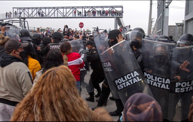 Familiares de presos forcejean con policías afuera del penal de Apodaca luego de darse a conocer la riña. EFE/G. Pérez