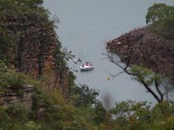 Un bote se ve hoy en el lago de Furnas, donde el sábado se desprendió la roca sobre botes turísticos. Labores de búsqueda continuaban en la zona. AP/I. do Vale