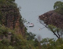 Un bote se ve hoy en el lago de Furnas, donde el sábado se desprendió la roca sobre botes turísticos. Labores de búsqueda continuaban en la zona. AP/I. do Vale