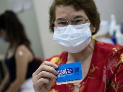 Un mujer muestra su carnet de vacunación anti COVID-19 después de recibir la cuarta dosis en Santiago, Chile. EFE/A. Valdes