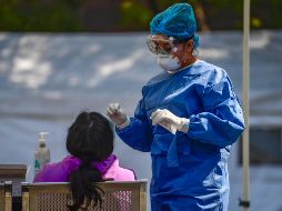 Personal sanitario realiza pruebas de detección de COVID al aire libre. AFP/P. Pardo