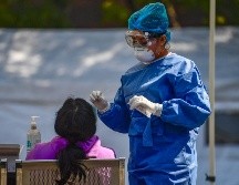 Personal sanitario realiza pruebas de detección de COVID al aire libre. AFP/P. Pardo