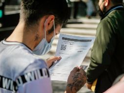 Un joven revisa su certificado de vacunación, obligatorio en Jalisco para entrar a eventos masivos. EL INFORMADOR/G. Gallo