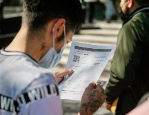 Un joven revisa su certificado de vacunación, obligatorio en Jalisco para entrar a eventos masivos. EL INFORMADOR/G. Gallo