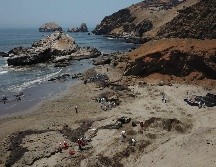 Cuadrillas de limpieza laboran para retirar petróleo de una playa en la provincia peruana del Callao, afectada por la erupción submarina en Tonga. AFP/C. Bouroncle