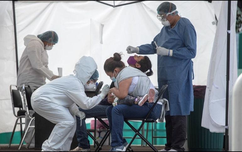 Una señora ayuda a su hija durante una prueba para detectar el COVID en el hospital del IMSS 