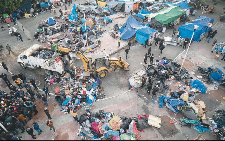 Limpieza. El campamento migrante tenía más de un año instalado en la plazoleta del cruce fronterizo El Chaparral, en Tijuana. AFP