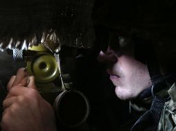 Un militar de Ucrania mira a través de un catalejo su posición no lejos de Novolugansk, región de Donetsk. AFP / A. Stepanov