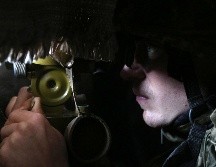 Un militar de Ucrania mira a través de un catalejo su posición no lejos de Novolugansk, región de Donetsk. AFP / A. Stepanov