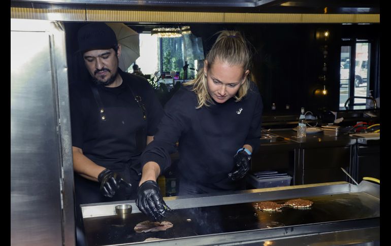 Javier Valenzuela y Marie Bouzková en la plancha con la carne. GENTE BIEN JALISCO/ CLAUDIO JIMENO