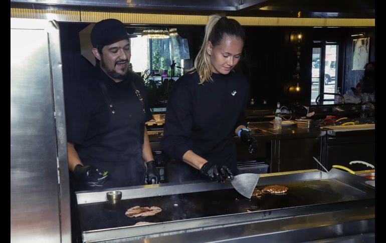 Javier Valenzuela y Marie Bouzková en la plancha con la carne. GENTE BIEN JALISCO/ CLAUDIO JIMENO